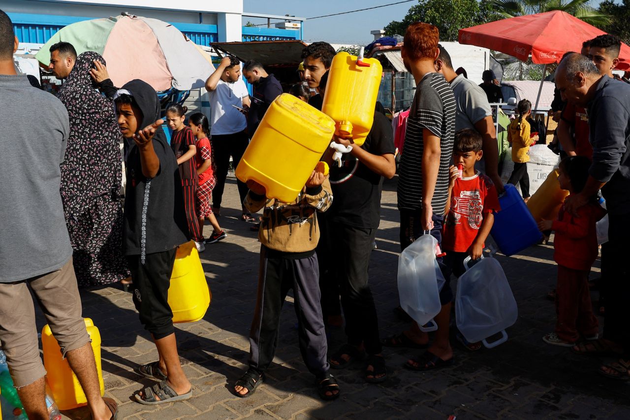 Palestinians queue for water as they take shelter at a United Nations-run centre in Khan Younis on October 26.