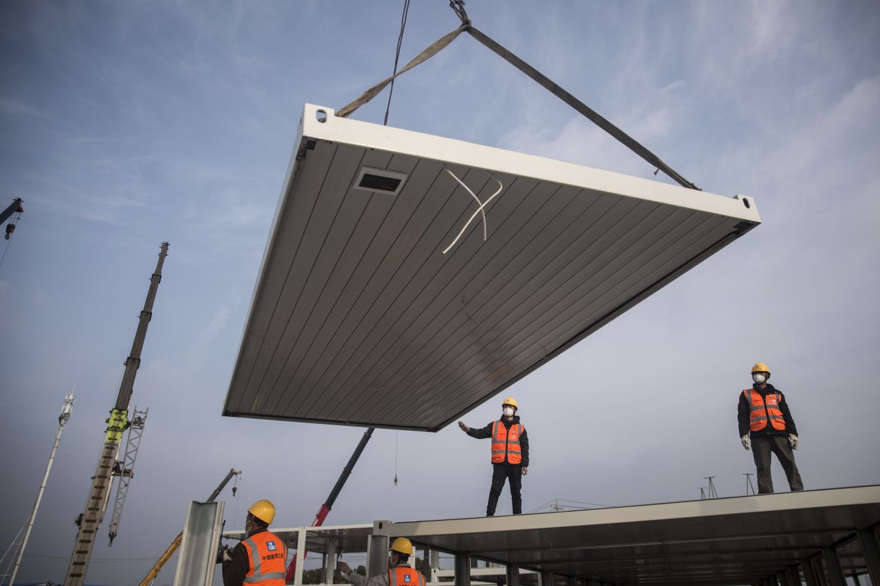  Construction workers guide a crane at the new Wuhan Huoshenshan hospital, built to tackle the coronavirus on January 28, 2020 in Wuhan.