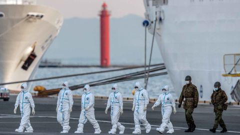 Japanese officials walk from the Diamond Princess cruise ship at Daikoku Pier in Yokohama on Monday.