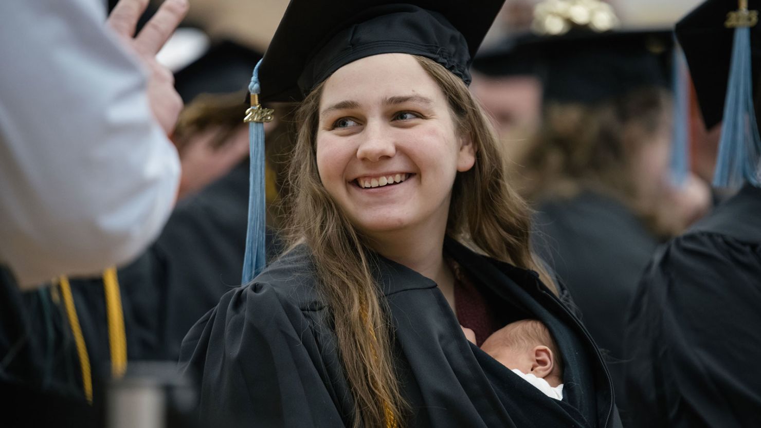Grace Szymchack graduated from Ferris State University on December 15 with her newborn, Annabelle, tucked into her gown.