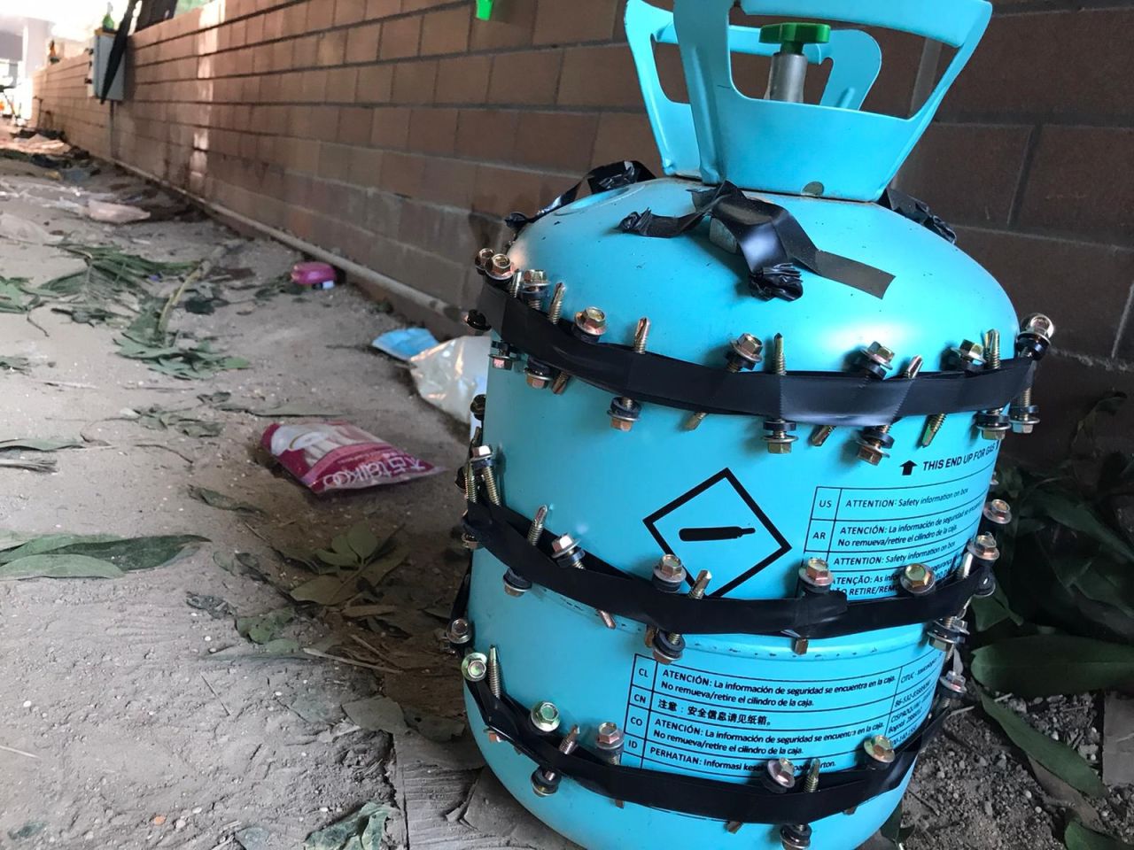 A photo shows what appears to be a makeshift bomb made from a gas canister with bolts attached.