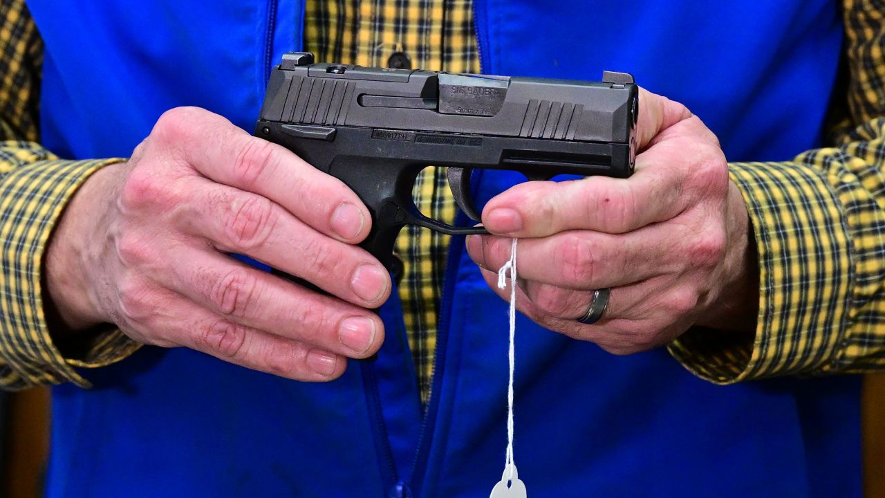 Patrick Jones, Shasta County supervisor and gun shop owner, displays a Sig Sauer Pistol on February 24, 2024 in Redding in Northern Califonia's Shasta County.