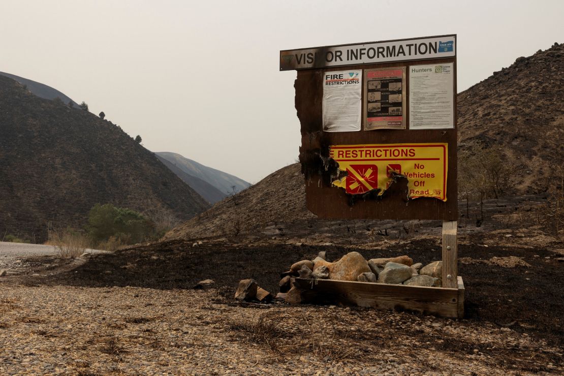 A burned visitor information sign from the Durkee Fire is seen amid charred hillside near Huntington, Oregon, U.S., July 27, 2024.