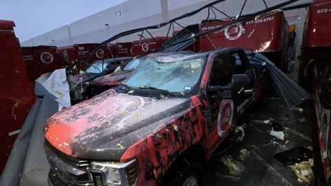 Debris piles on vehicles in Lewisville, Texas, on Tuesday after a storm with powerful winds swept through the area