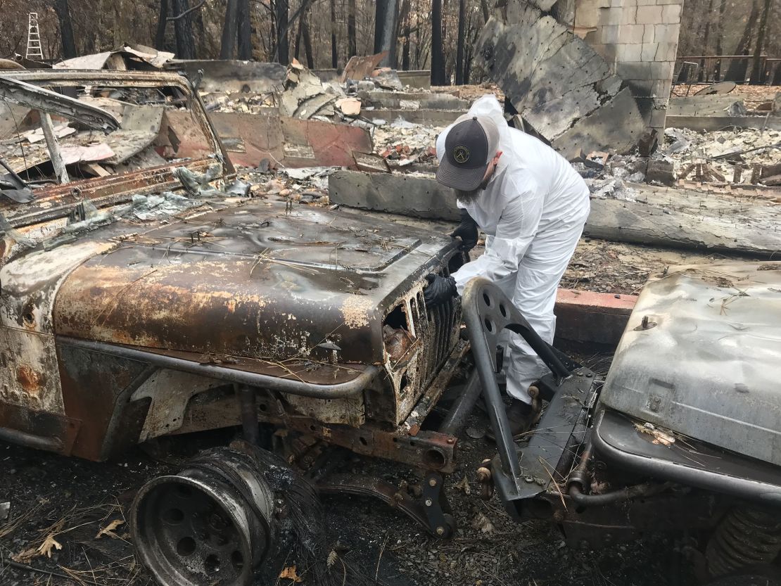 Michael Daneau examines damage to the couple's home, which was destroyed by the Camp Fire in 2018.