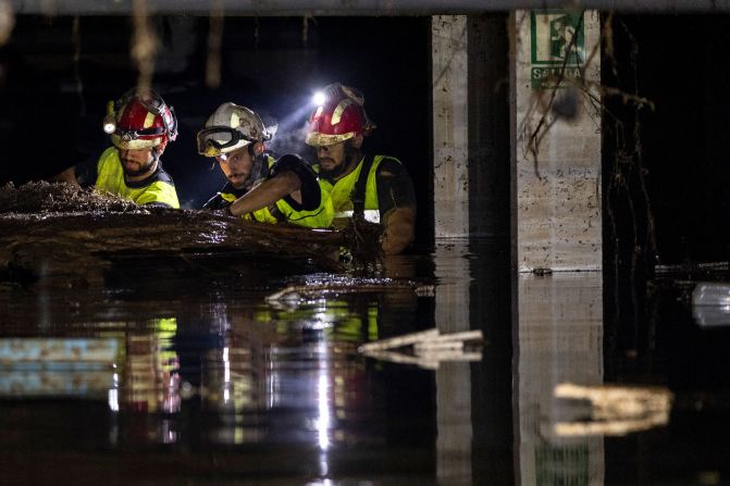 Emergency Military Unit members search for a missing person in a parking garage in Picanya on Saturday.