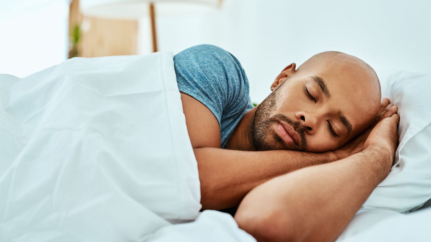 Cropped shot of a young man sleeping in his bed