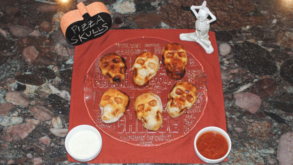 Pizza Skulls halloween food on red plate.