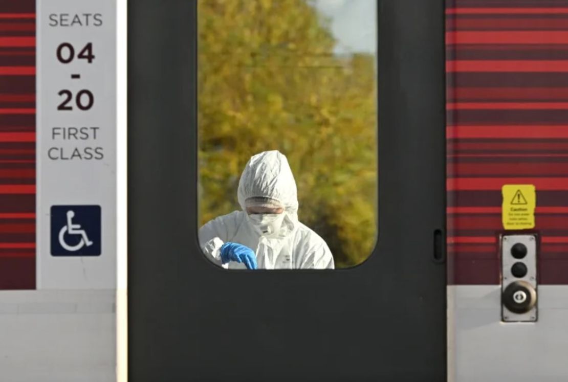 Un agente de policía forense examina el tren de LNER mientras se encuentra estacionado en la estación de Huntingdon el domingo.