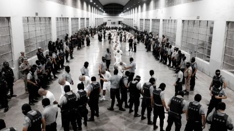 En esta fotografía obtenida el 16 de marzo de la Oficina de Prensa de la Presidencia de El Salvador, oficiales de policía salvadoreños escoltan a venezolanos recientemente deportados por el gobierno de Estados Unidos en la prisión del Centro de Reclusión del Terrorismo en Tecoluca, El Salvador.