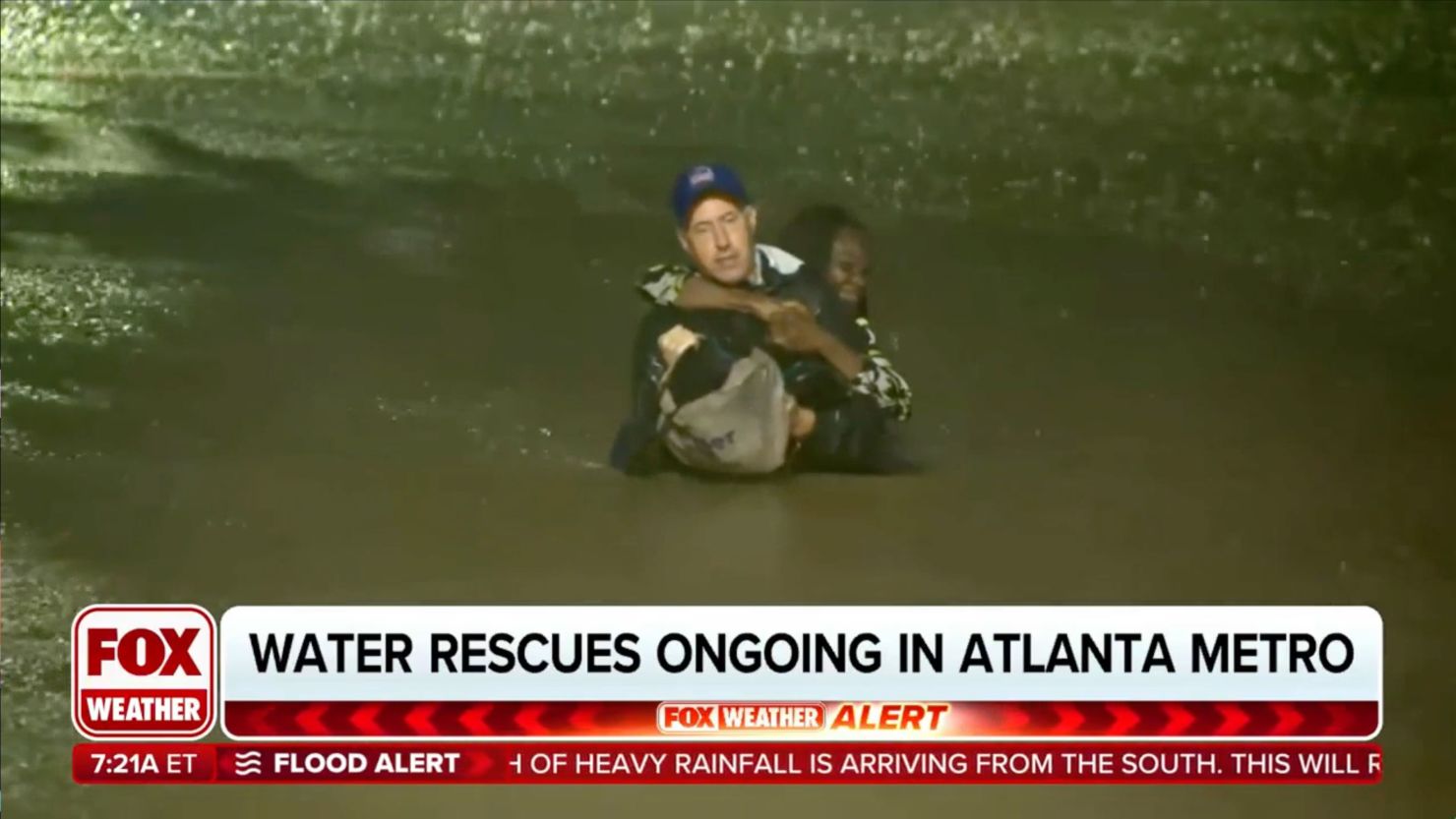 Meteorologist Bob Van Dillen rescues Angelina Madut after her car became trapped by flood waters.