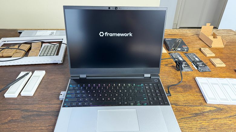The Framework Laptop 16 surrounded by its parts as its logo is on screen.