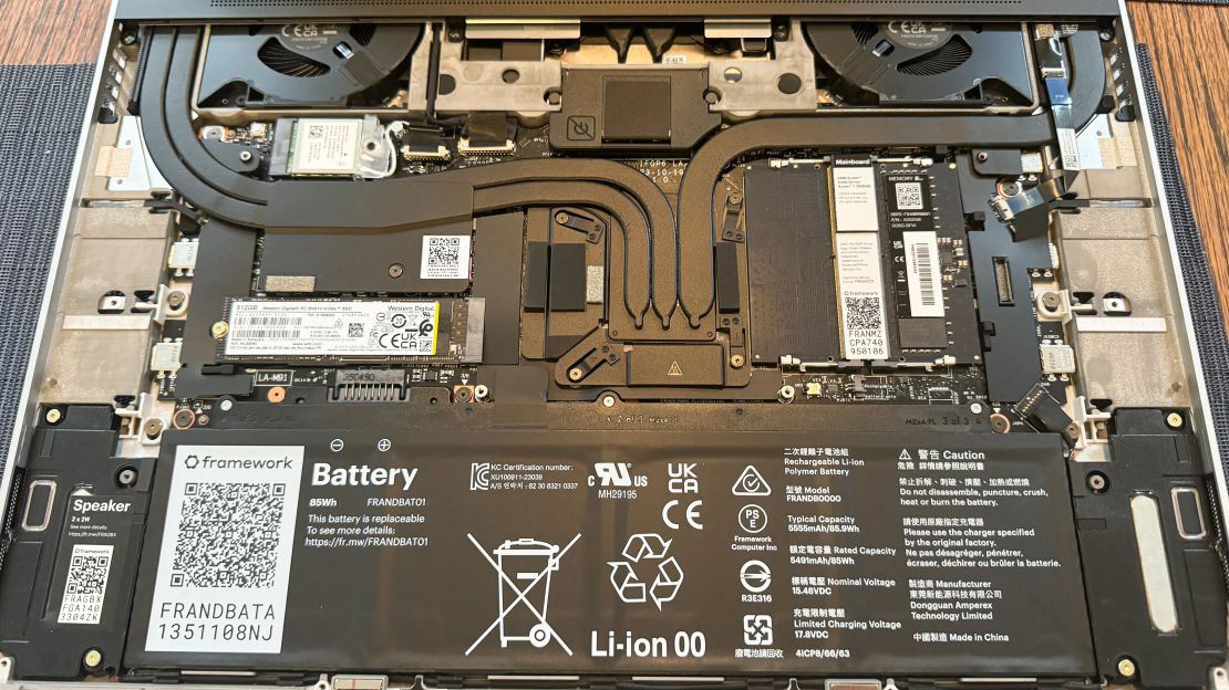 The Framework Laptop 16’s internal parts including SSD and RAM are visible.