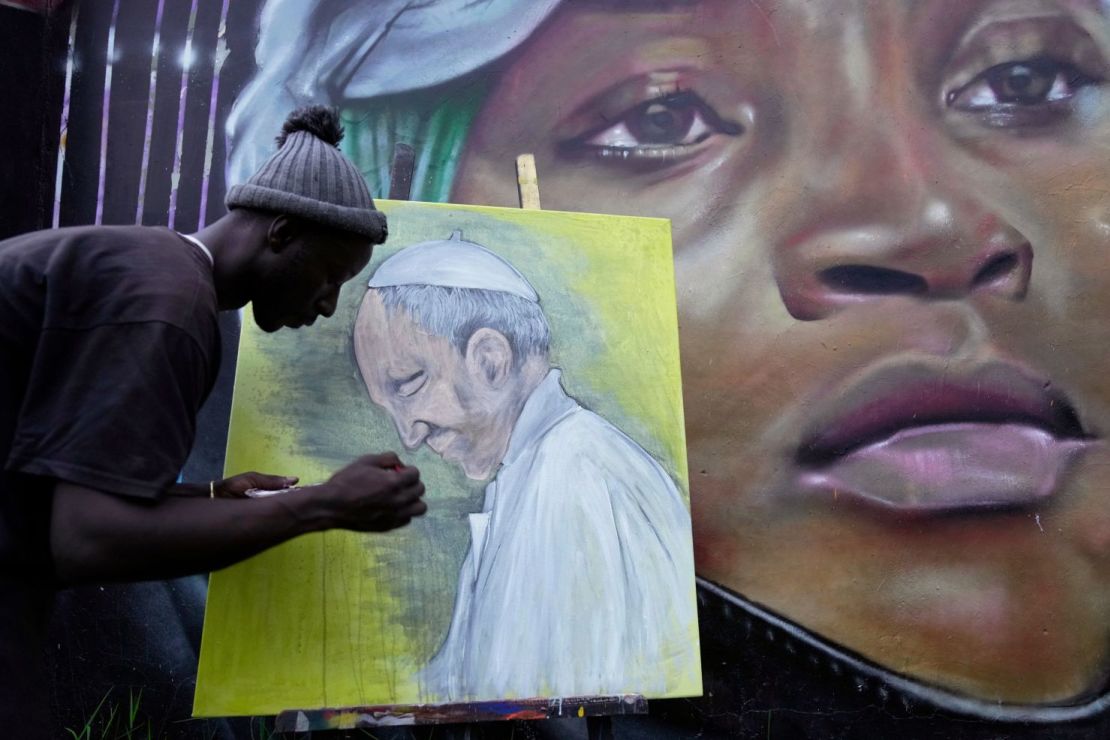 El artista de grafiti Alexander Ikawah pinta al papa Francisco en un lienzo en Nairobi.
