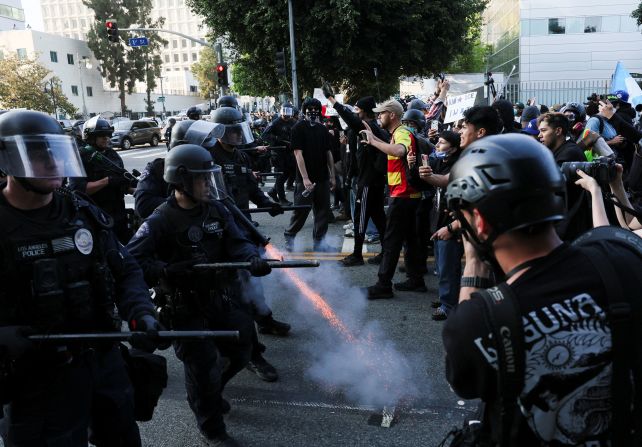 A police officer fires a crowd control munition into the ground while confronting demonstrators in Los Angeles on Monday, June 9.