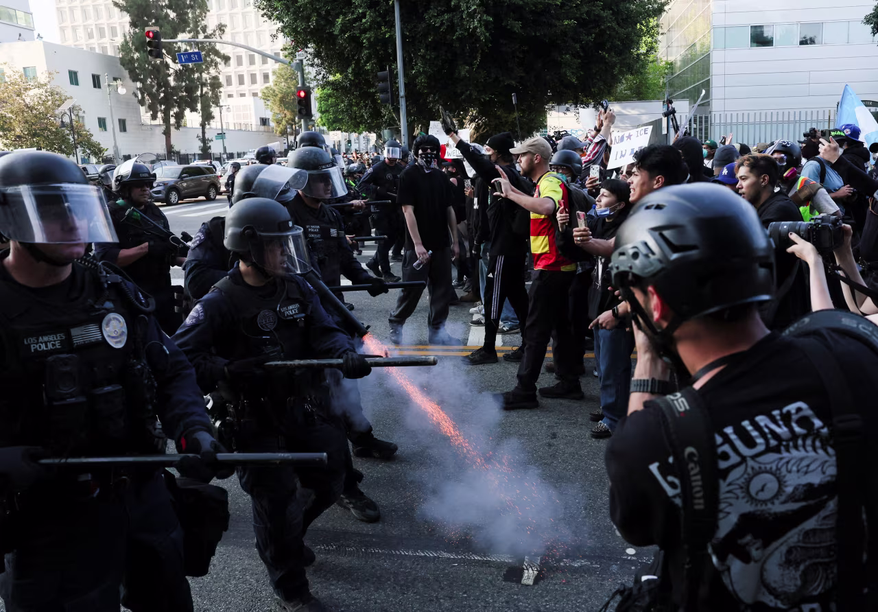 A police officer fires a crowd control munition into the ground while confronting demonstrators in Los Angeles on Monday, June 9.