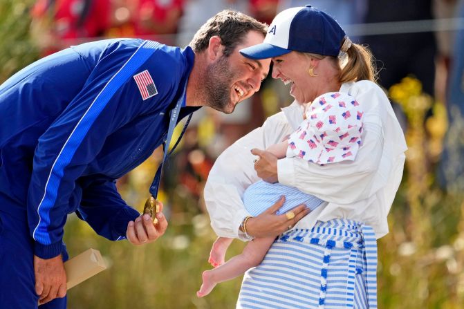 American golfer <a >Scottie Scheffler </a>celebrates with his wife, Meredith Scudder, and their son, Bennett, after <a >winning gold</a> on August 4. Scheffler carded a 9-under 62 in the final round.