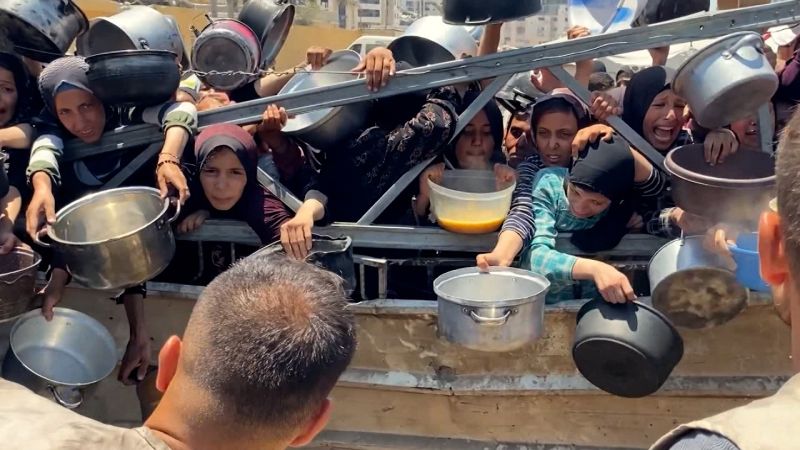 Desperate people cling to empty pots waiting for food in Gaza
