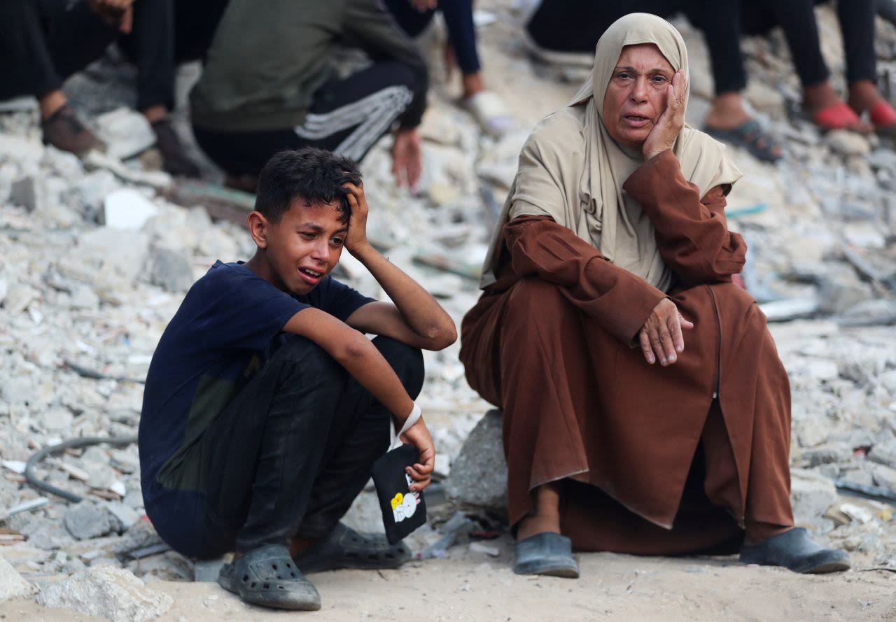La gente llora en un funeral por los palestinos muertos por fuego israelí mientras intentaban recibir ayuda y otros que murieron en un ataque israelí nocturno, según los médicos, en el Hospital Al-Shifa en la Ciudad de Gaza, el sábado.