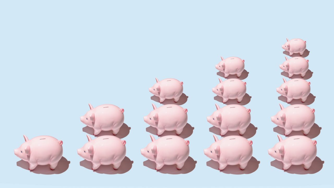 Multiple piggy banks arranged in stacks forming a bar graph on a blue background