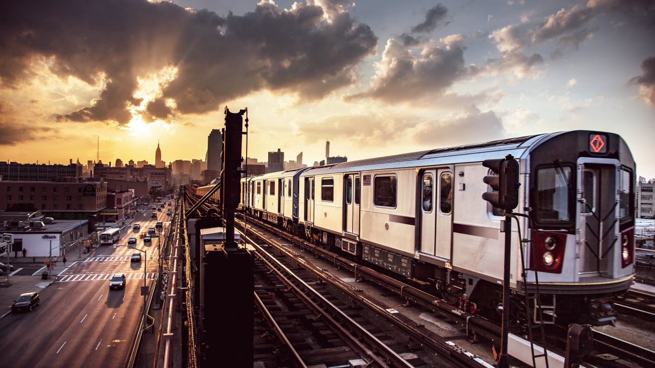 An NYC subway train on elevated tracks in the borough of Queens.