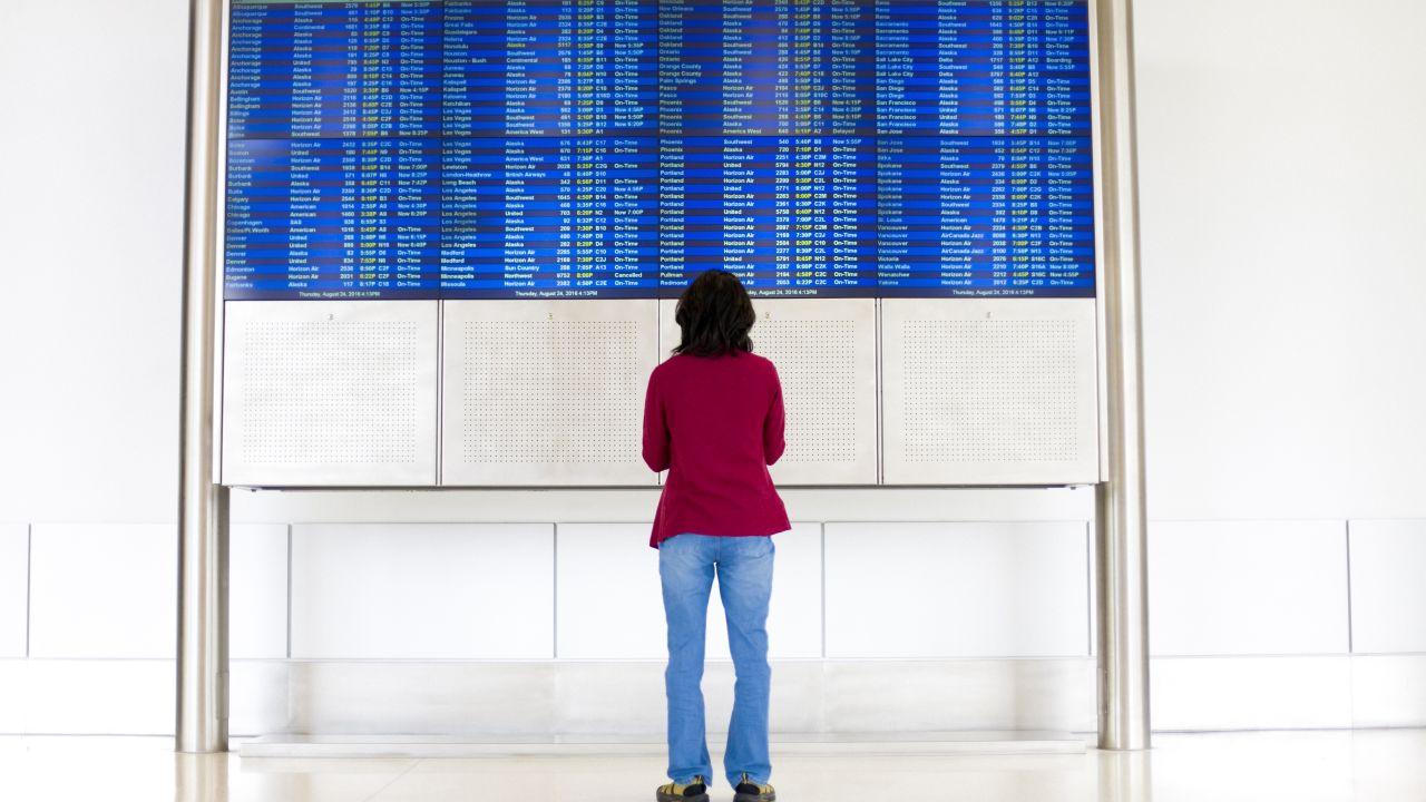 Person looking at a flight board with delays.