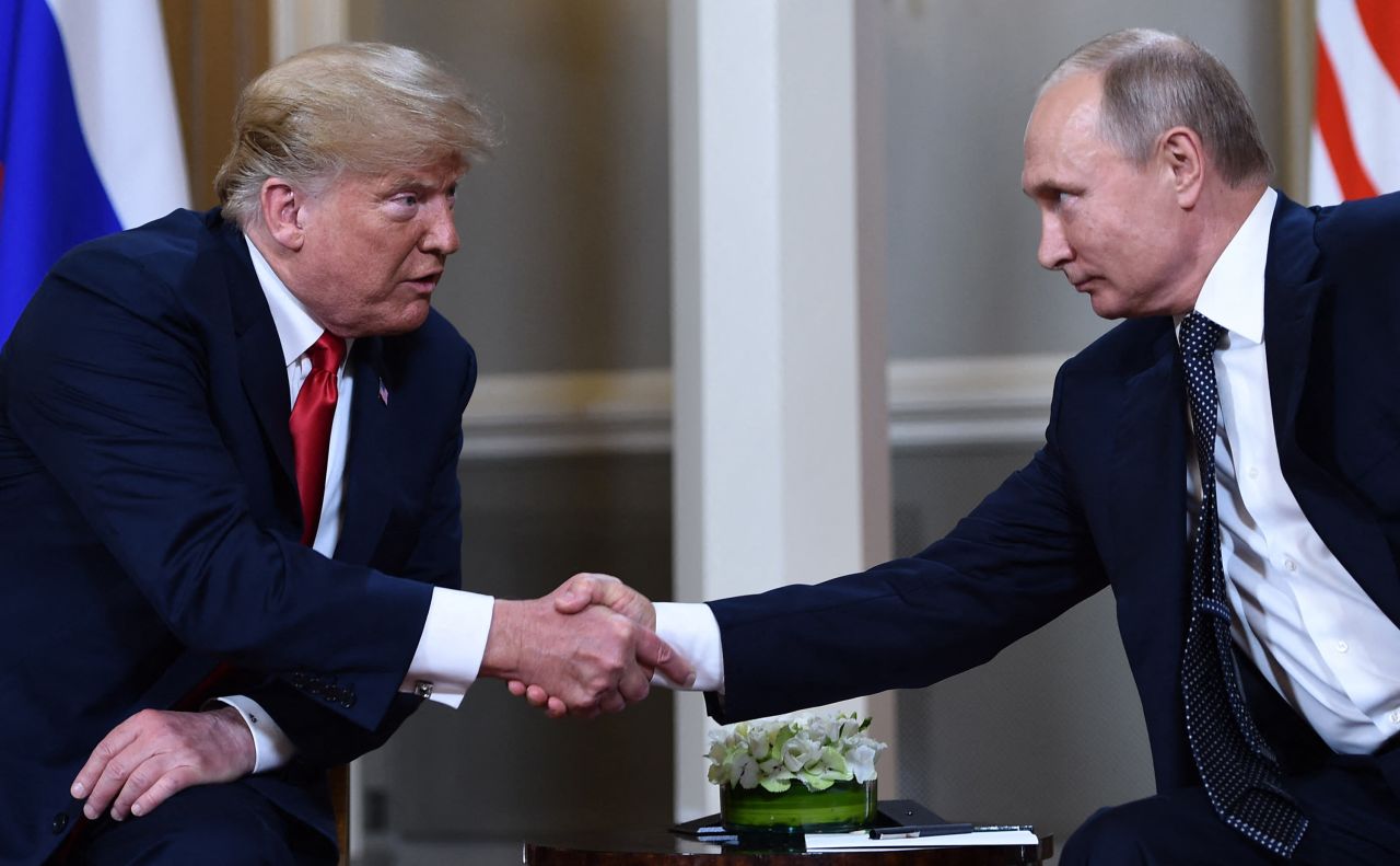 US President Donald Trump and Russian President Vladimir Putin shake hands before a meeting in Helsinki on July 16, 2018.