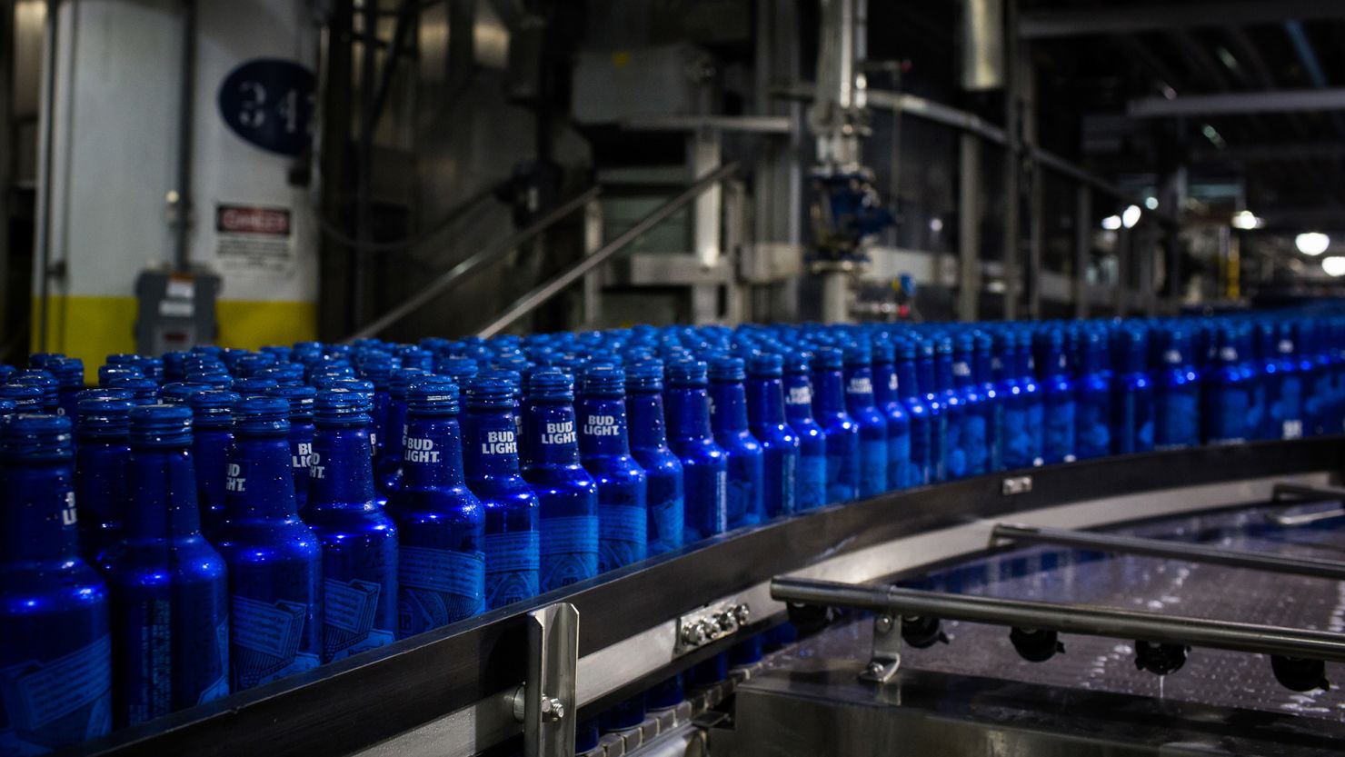 Bottles of Bud Light beer move along a conveyor at an Anheuser-Busch InBev facility in St. Louis, Missouri, United States, in July 2018.