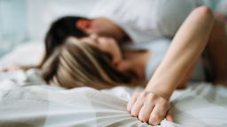 Portrait of young attractive loving couple in bedroom