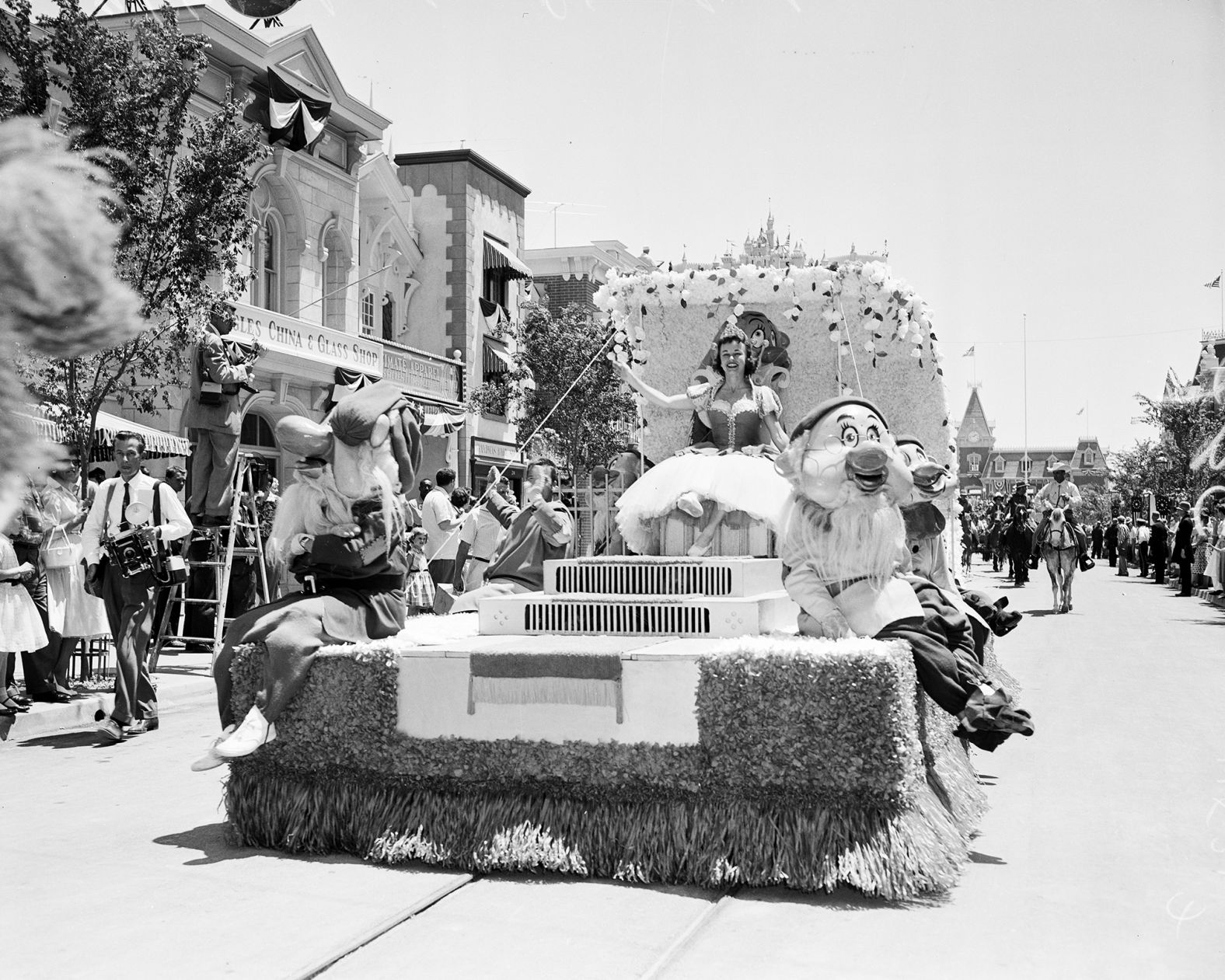 Snow White and the Seven Dwarves ride a float and wave to the crowd.