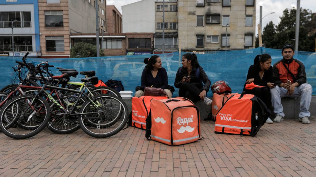 Venezualen nationals working as bicycle couriers, for Colombian online delivery company "Rappi", wait for orders in Bogota, on October 11, 2018. - After meeting the challenges of Latin American economies, a group of digital companies have become a new generation of unicorns by reaching (and exceeding) the value of 1,000 million dollars, a dream of thousands of start-ups in the region. (Photo by John VIZCAINO / AFP)        (Photo credit should read JOHN VIZCAINO/AFP via Getty Images)