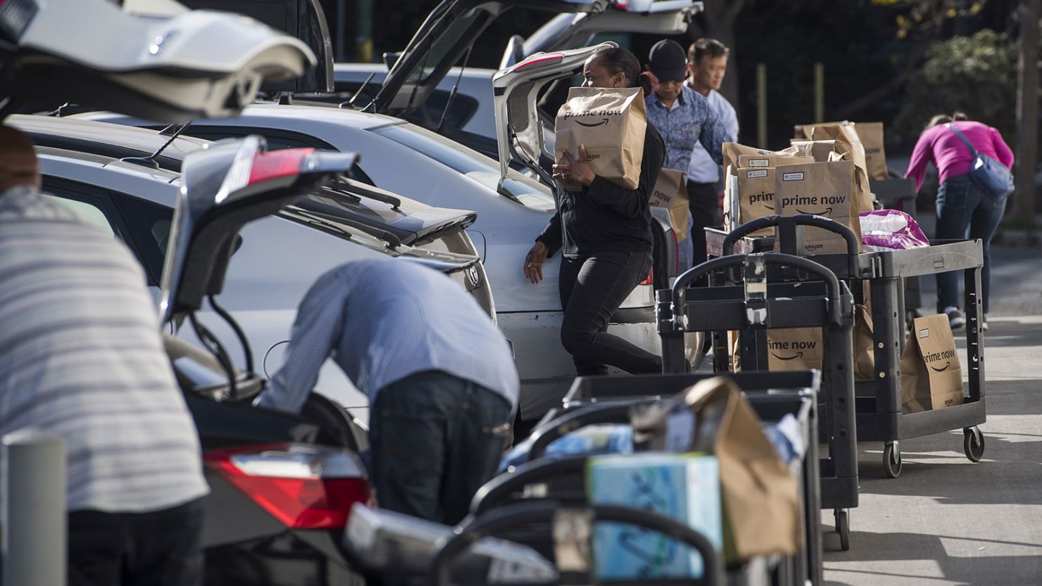 Contractors working for the Amazon Inc. Flex program load packages into vehicles to deliver to customers in San Francisco, California, on Tuesday, October 30, 2018.