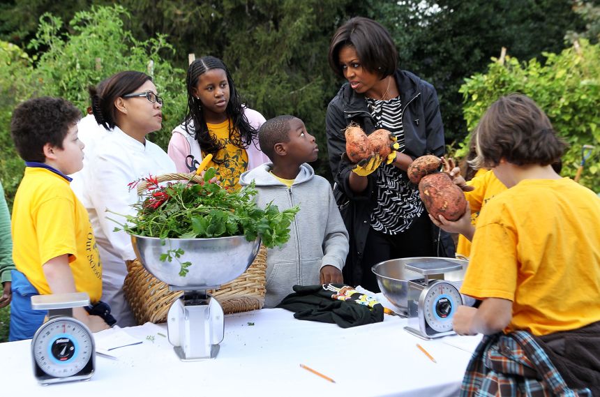 First lady Michelle Obama talks to White House Executive Chef Cristeta Pasia Comerford as local 5th graders look on during the White House Kitchen Garden Fall Harvest on October 20, 2010.