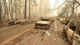 A fallen power line is seen on top of burnt out vehicles on the side of the road in Paradise, California after the Camp fire tore through the area on November 10, 2018.