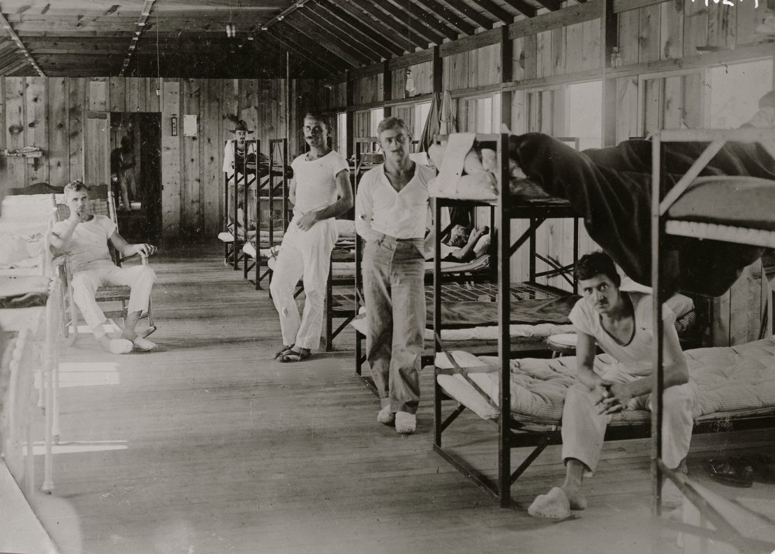 This portrait shows interned men in a dormitory at Fort Douglas, Utah, in 1918. The site housed German and German American civilians perceived to be potential threats during World War I. It also housed German prisoners of war and American conscientious objectors.