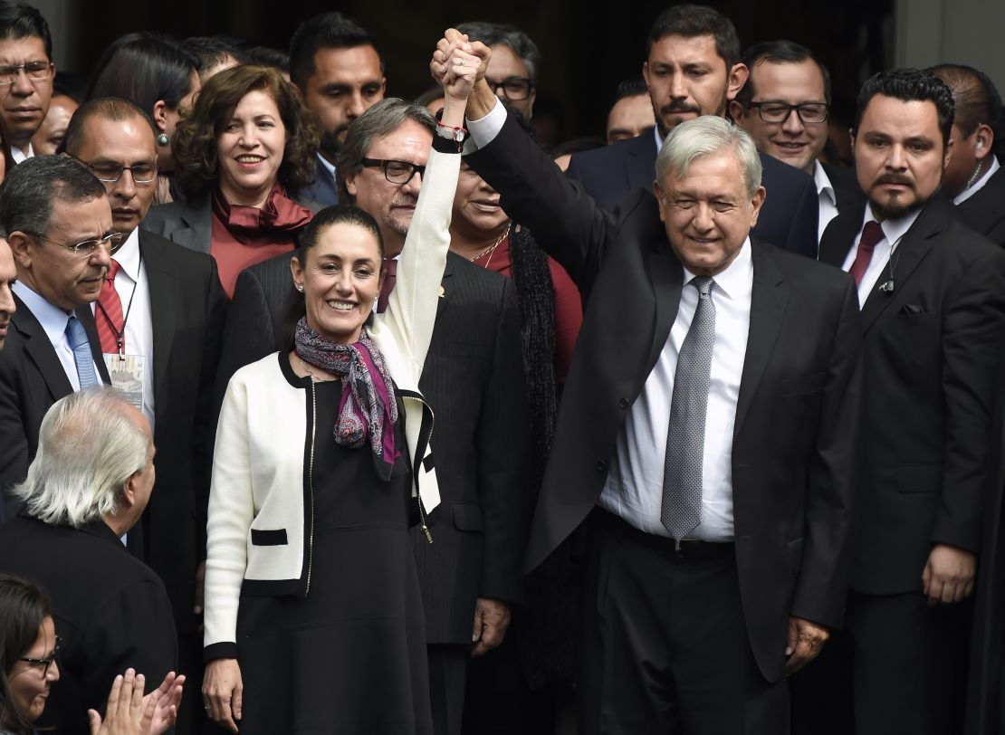 Mexican President Andres Manuel Lopez Obrador (right) raises the hand of Claudia Sheinbaum (left), after her swearing-in ceremony as Mexico City mayor on December 5, 2018.