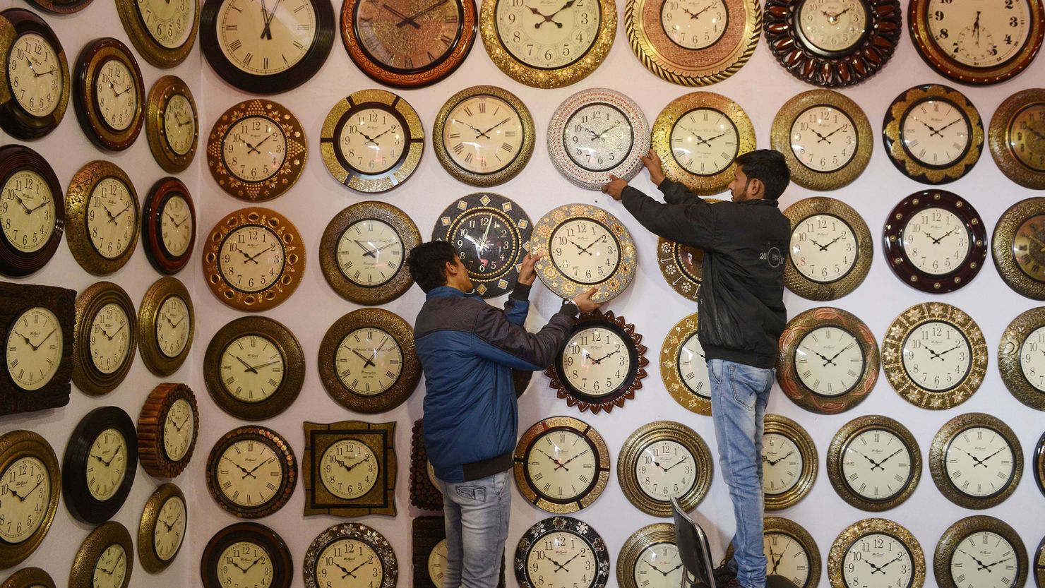 Indian exhibitors hang wall clocks for sale during the 'Punjab International Trade Expo (PITEX) in Amritsar on December 6, 2018.