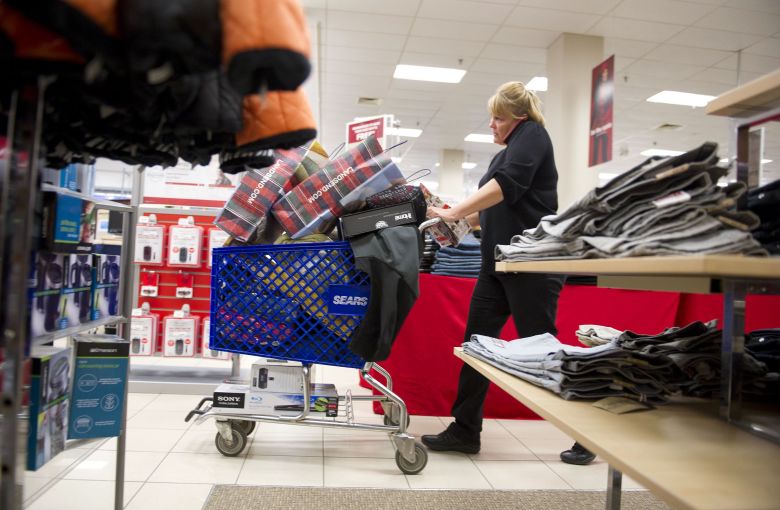 A woman talks on her cell phone as she shops in a Sears store at Simon Property Group's Great Lakes Mall in Mentor, Ohio, on Black Friday, November 26, 2010.