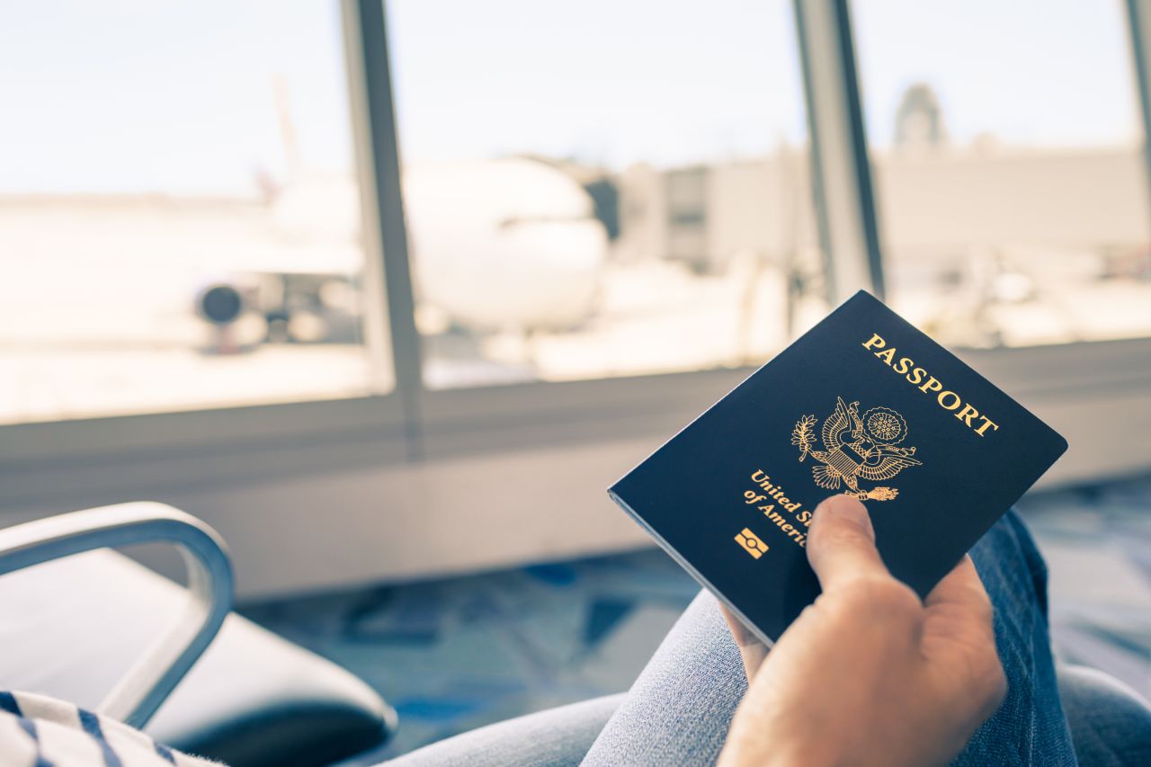 A traveler holds a US passport in an undated image.