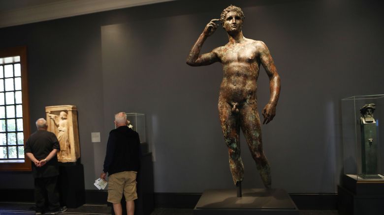 LOS ANGELES, CALIFORNIA - DECEMBER 13:  The statue known as 'Victorious Youth' (CENTER R) is displayed at the Getty Villa on December 13, 2018 in Los Angeles, California. After a ten-year legal battle, the top court in Italy has ruled that the 2,000-year-old bronze statue should be returned to Italy by the Getty museum. Italian officials say the statue was found in Italian territorial waters while the Getty Trust argues the statue was discovered in international waters. (Photo by Mario Tama/Getty Images)