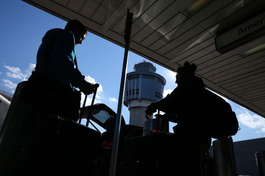 The air traffic tower is seen as commuters gather their luggage at LaGuardia Airport on January 25, 2019, as flights were stopped due to staff shortages during the partial government shutdown.