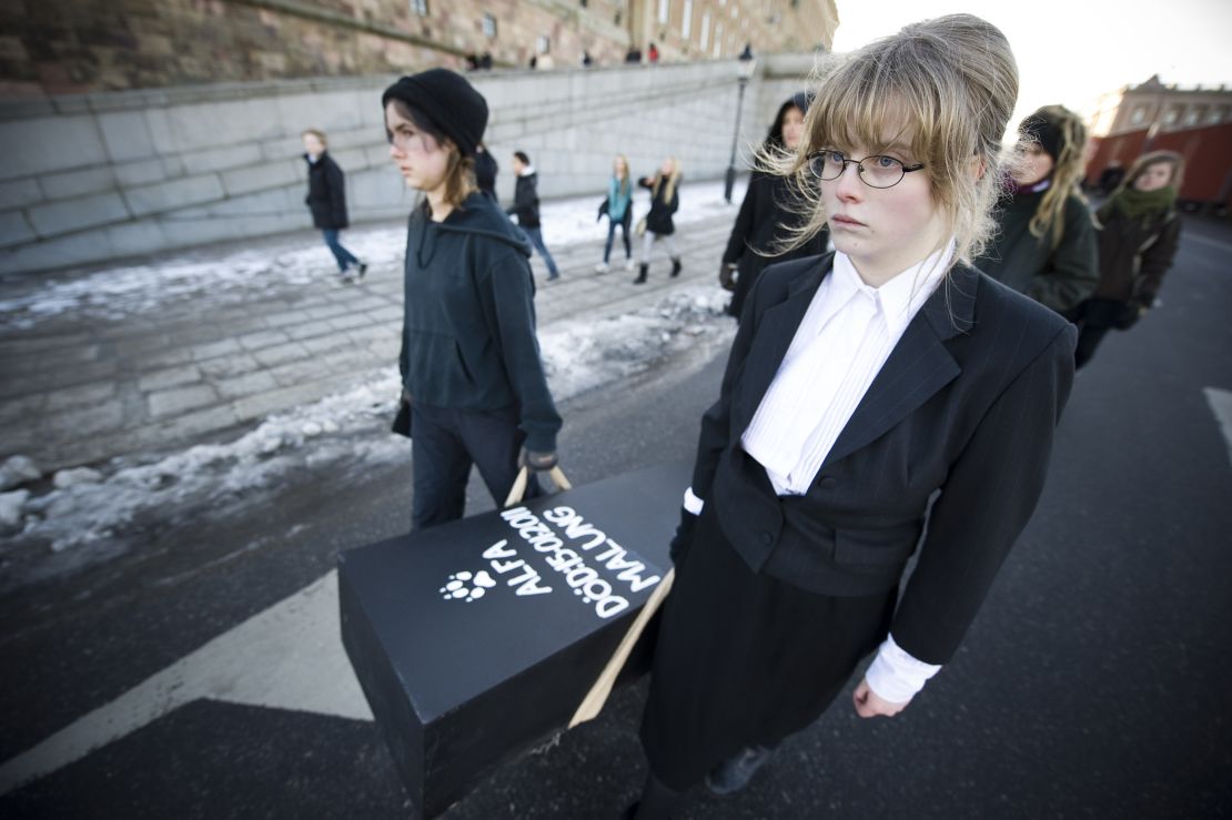 Swedish protestors march with 20 coffins, one for each wolf killed during recently sanctioned hunt, as part of a protest funeral procession in central Stockholm on February 6, 2011. The hunt follows a 2009 decision by the Swedish parliament to limit the wolf population in Sweden, which had been on the brink of extinction until recently. The move has sparked criticism from environmental groups, as well as the European Union, which launched legal action against the country on Thursday. AFP PHOTO/JONATHAN NACKSTRAND (Photo credit should read JONATHAN NACKSTRAND/AFP via Getty Images)