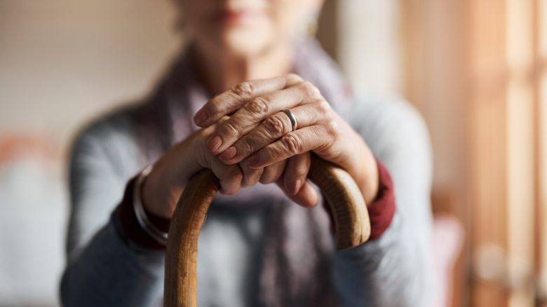 Cropped shot of a senior woman holding a cane in a retirement home