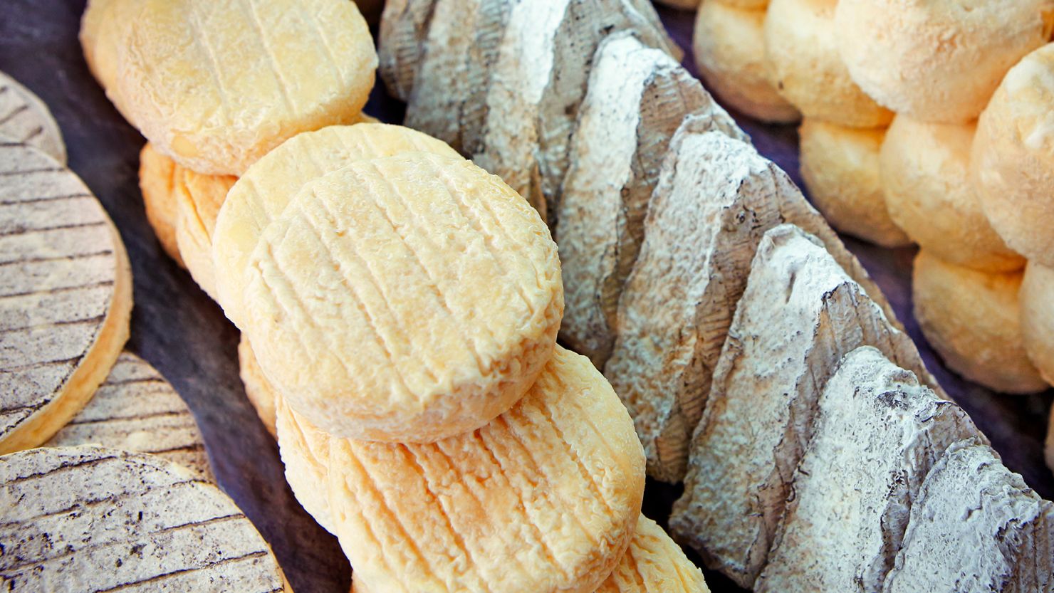 Various types of traditional French cheeses one might encounter on a visit to Paris.