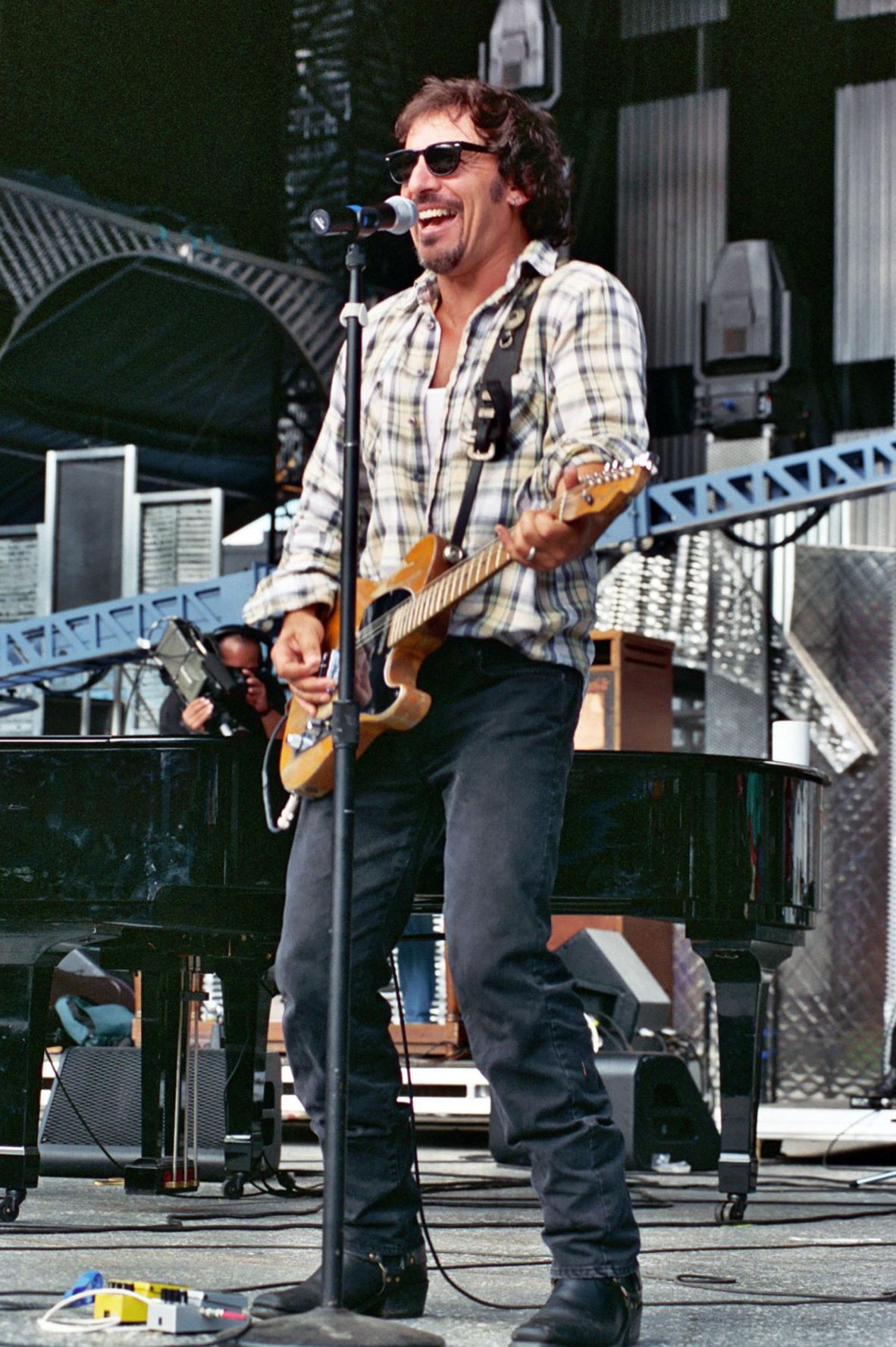 Fitted jeans, biker boots and well-worn plaid flannel are lynchpins of Bruce Springsteen's closet. Photographed here, the rockstar plays at the Grand Opening of Rock and Roll Hall of Fame Museum in Cleveland, 1995.