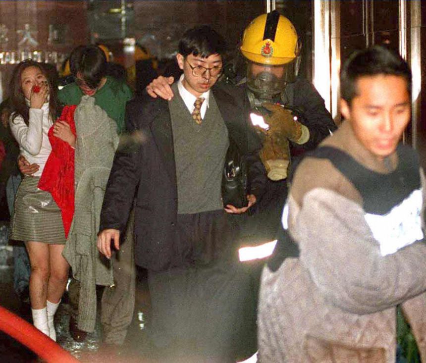 Постраждалих евакуювали з місця руйнівної пожежі, яка спалахнула в караоке-барі в Гонконзі 25 січня 1997 року.