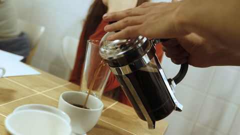 TO GO WITH AFP STORY BY ROBERT MAHERSONA man pours coffee in a cup on April 7, 2011 in a cafe as it hosts a frog fight, a monthly throwdown for baristas in Paris. It's famous for its sun-kissed sidewalk cafes, but Paris has lagged well behind New York, London and Sydney as a Mecca for connoisseurs of fine coffee -- until now. Gourmet coffee bars and small-batch roasteries are popping up in the French capital, introducing locals to thick rich espressos, artful lattes and the idea that a cup of Joe can be savoured like fine wine. AFP PHOTO FRANCOIS GUILLOT (Photo credit should read FRANCOIS GUILLOT/AFP via Getty Images)