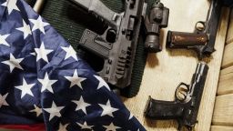 Rifles, guns and American flag on table