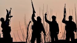 TOPSHOT - US-backed Syrian Democratic Forces (SDF) fighters celebrate after fighting Islamic State (IS) group jihadists near the village of Baghouz in the eastern Syrian province of Deir Ezzor, on March 15, 2019. Hundreds of men, women and children trudged out of the Islamic State group's last sliver of territory on March 14 as US-backed Syrian fighters once again slowed their advance to crush the "caliphate". (Photo by GIUSEPPE CACACE / AFP) (Photo by GIUSEPPE CACACE/AFP via Getty Images)