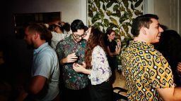 Woman kissing boyfriend on cheek during date in night club